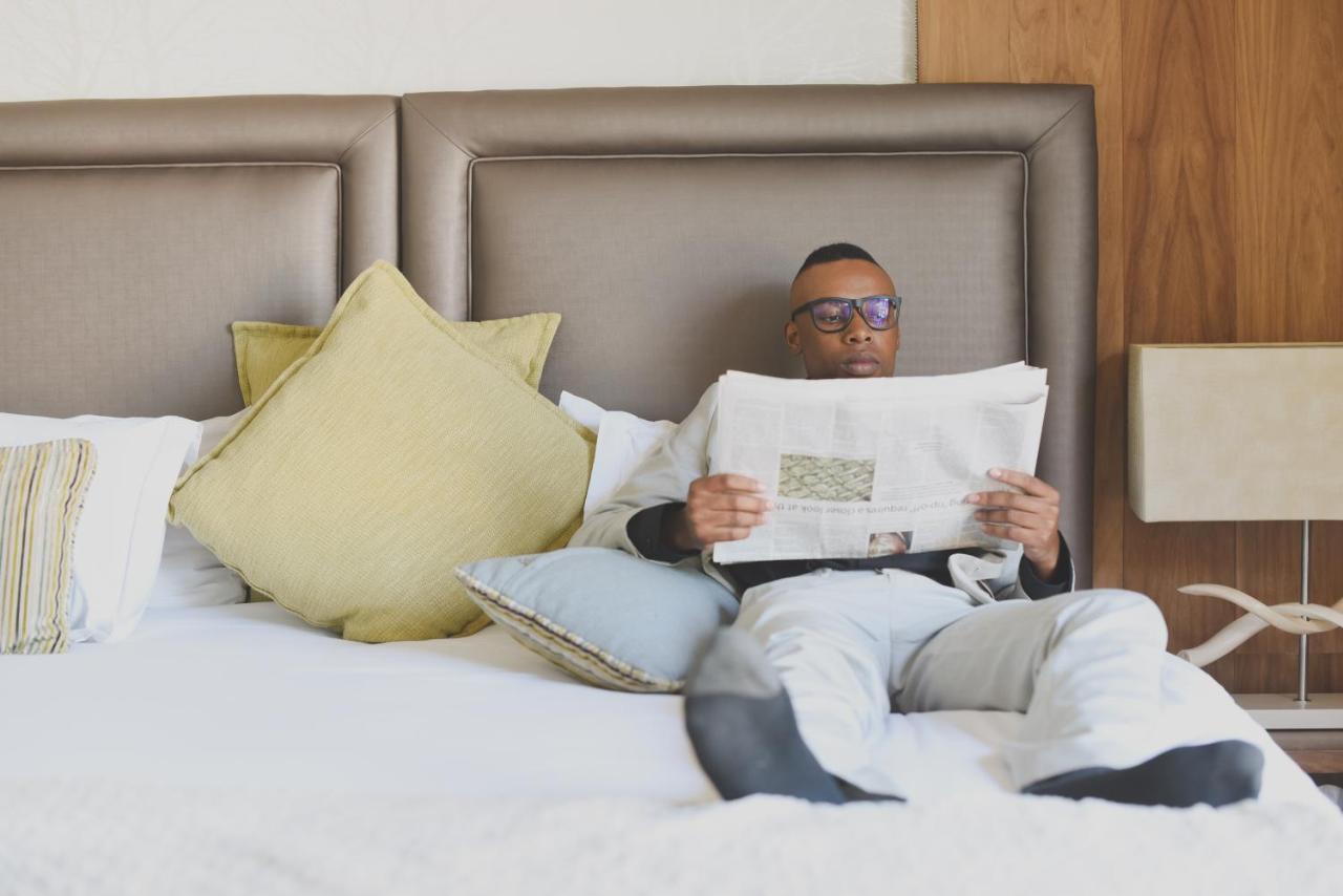 Menlyn Boutique Hotel Pretoria Exterior photo A man reading a newspaper