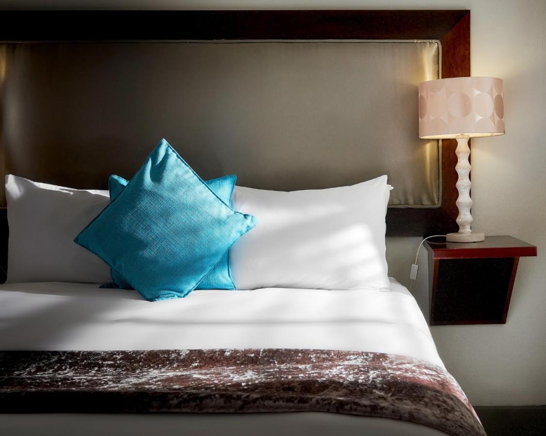Menlyn Boutique Hotel Pretoria Exterior photo A bed with a blue throw pillow