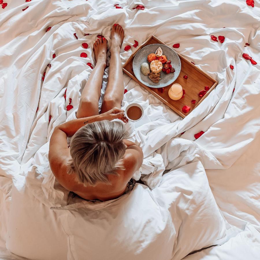 Menlyn Boutique Hotel Pretoria Exterior photo A woman in bed with a tray of food